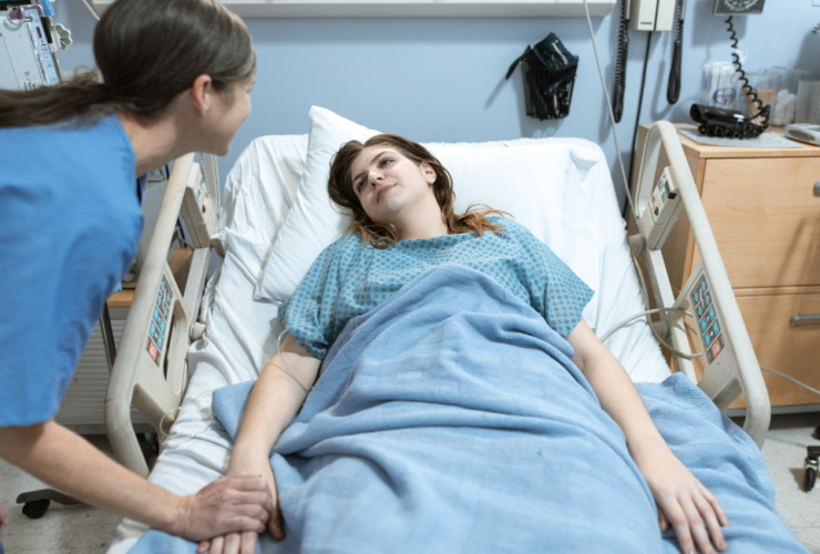 Profissional de saúde a realizar cuidados de enfermagem preventivos num doente acamado para evitar úlceras de pressão e escaras.